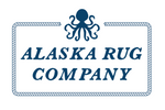 A navy blue logo for Alaska Rug Company, featuring a stylized octopus above a rope-bordered rectangular frame on a white background.